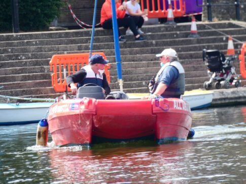 Instructor teaching participant how drive a powerboat via the RYA Powerability Scheme.
